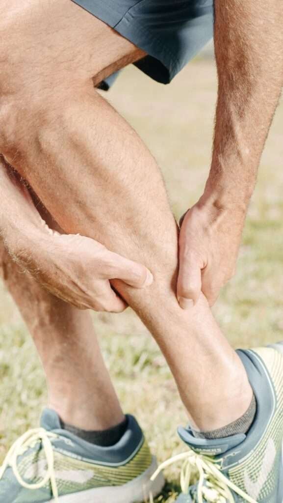 Runner massaging a sore calf muscle
