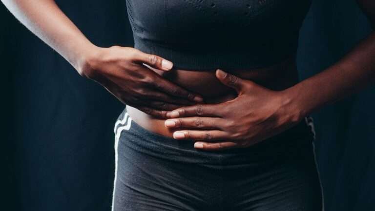 Person holding their lower abdomen